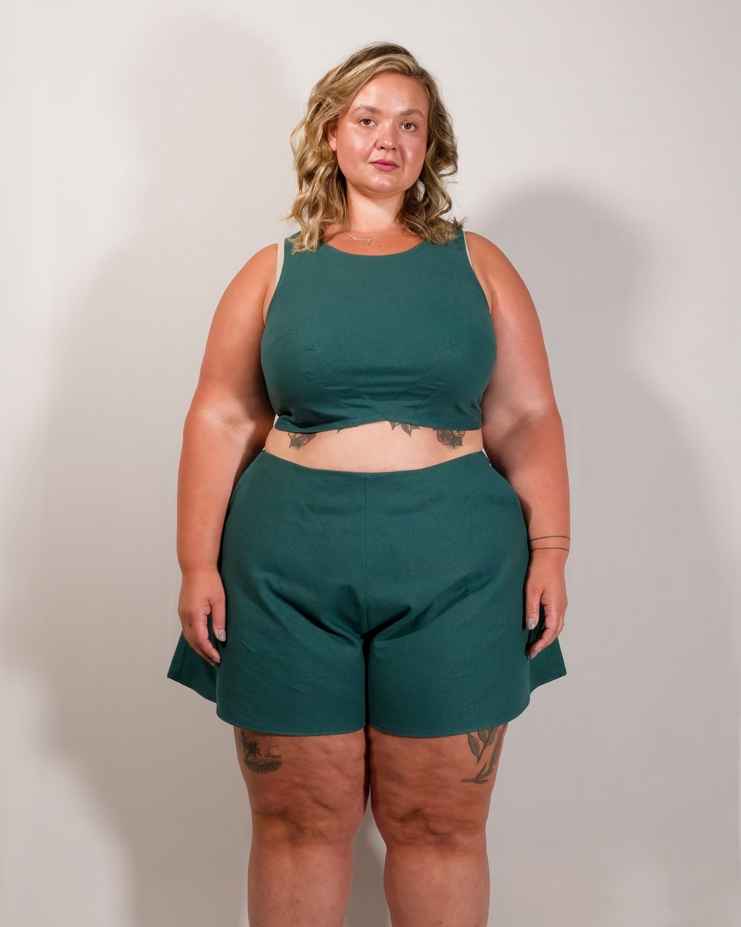 Front of flared shorts in deep emerald. Tidy front seam and no visible waistband. Paired with matching sleeveless crop top.