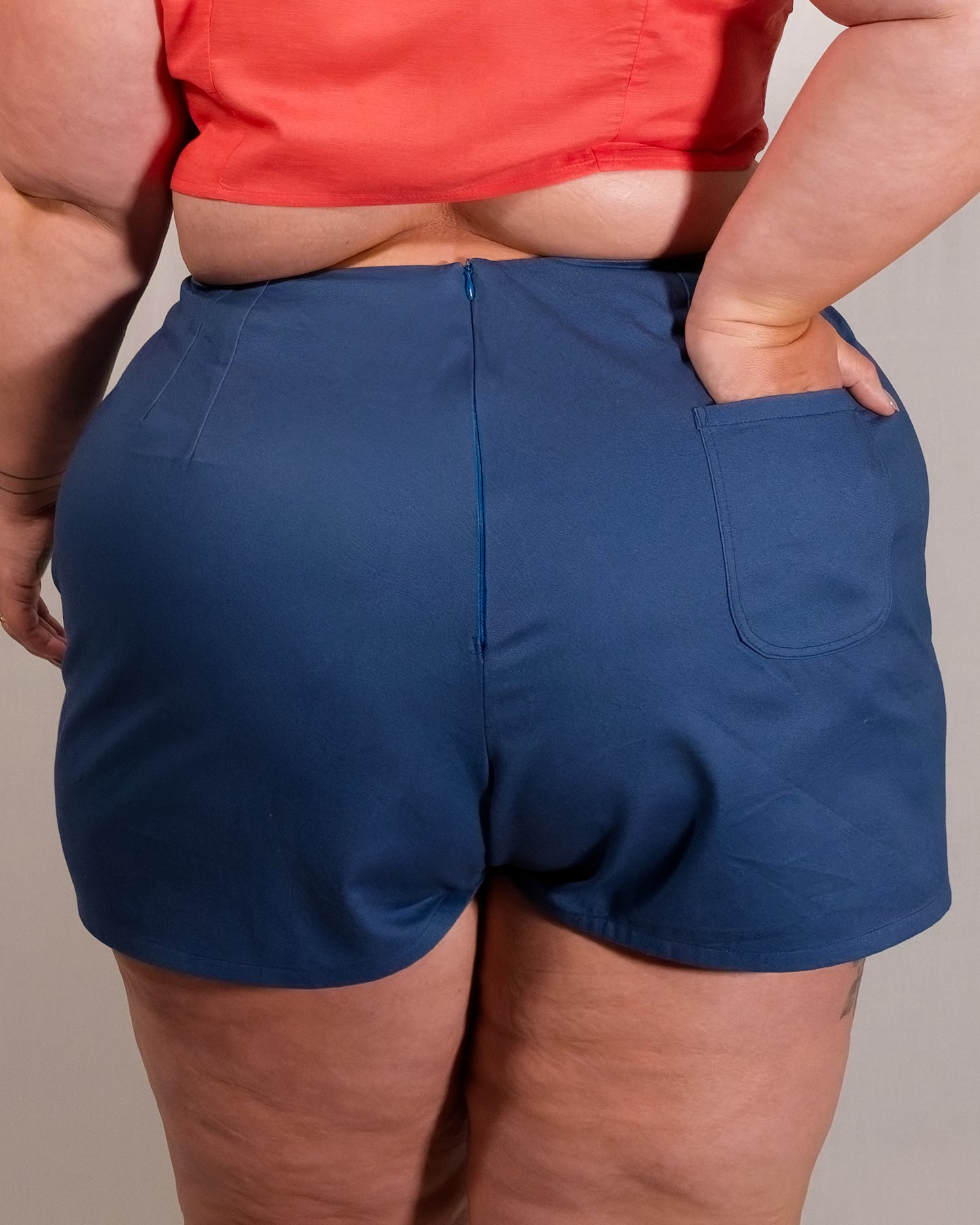 Back of Kingfisher A-line shorts in dark blue. Hidden zipper closure centre-back and a single back pocket on the right.