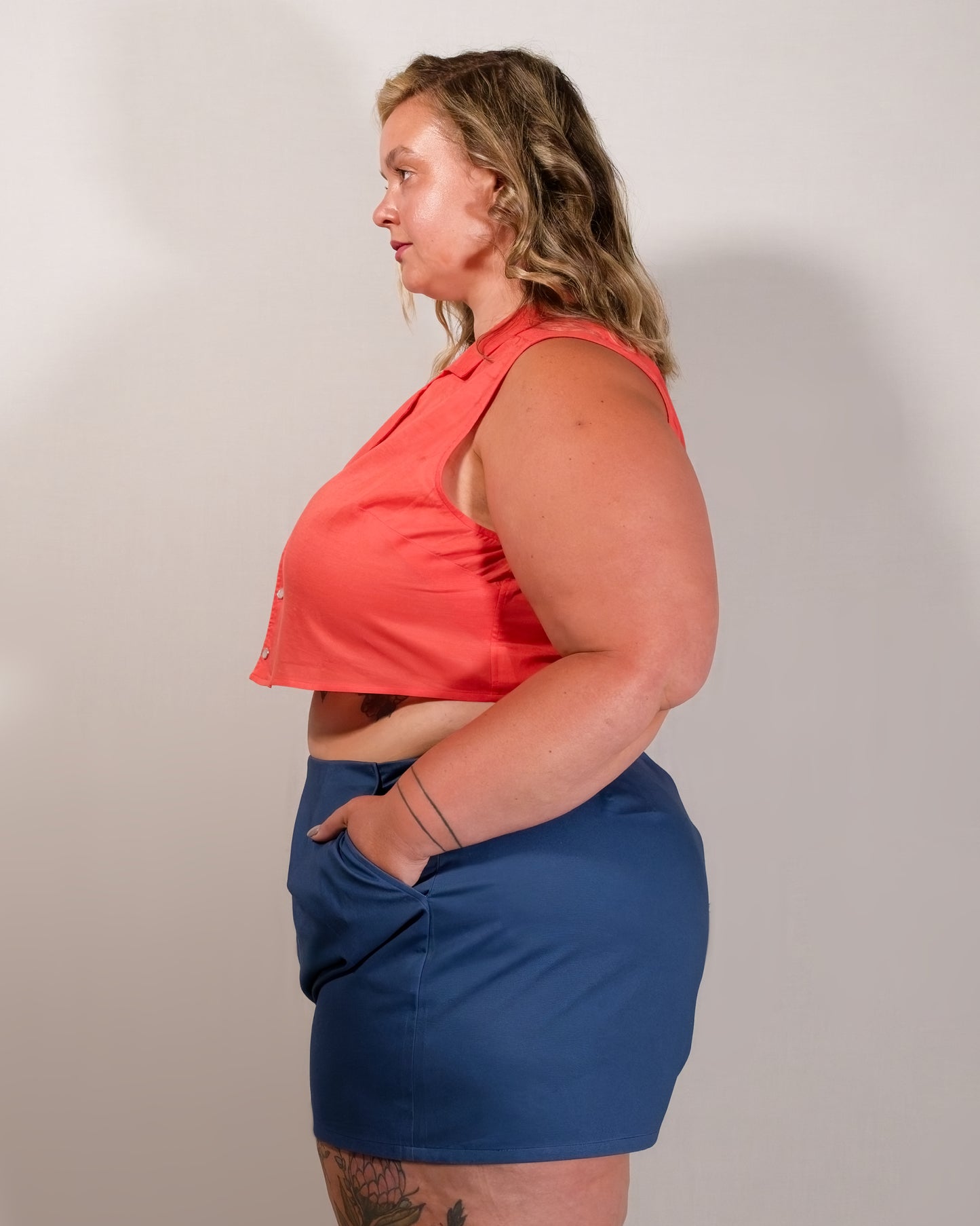 Left side of Kingfisher A-line shorts in dark blue. Model has hand in pocket.