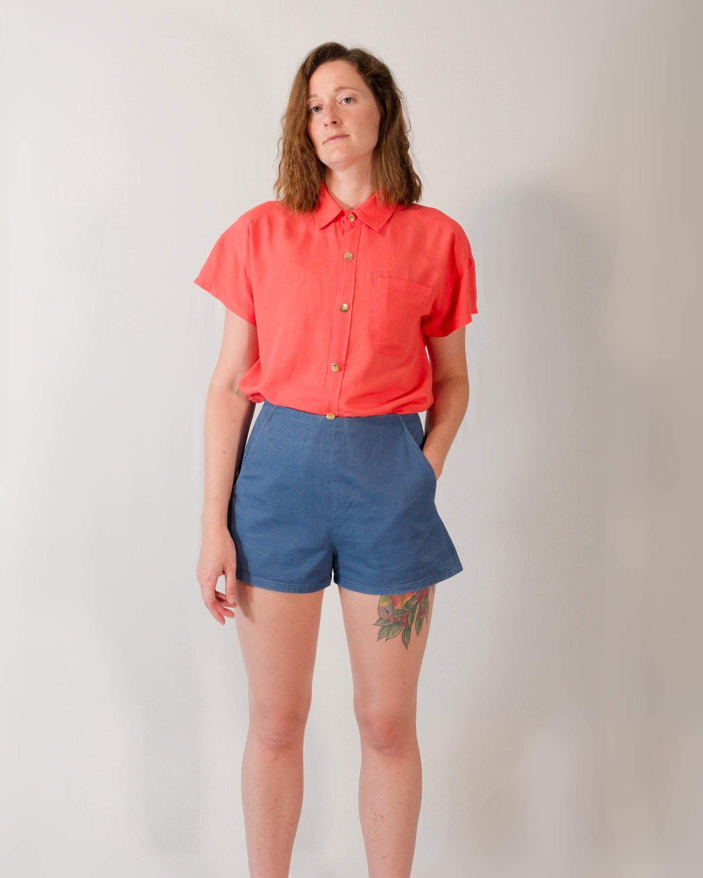 Front of Kingfisher A-line shorts in dark blue. Paired with a short-sleeved blouse in callistemon red, tucked in.