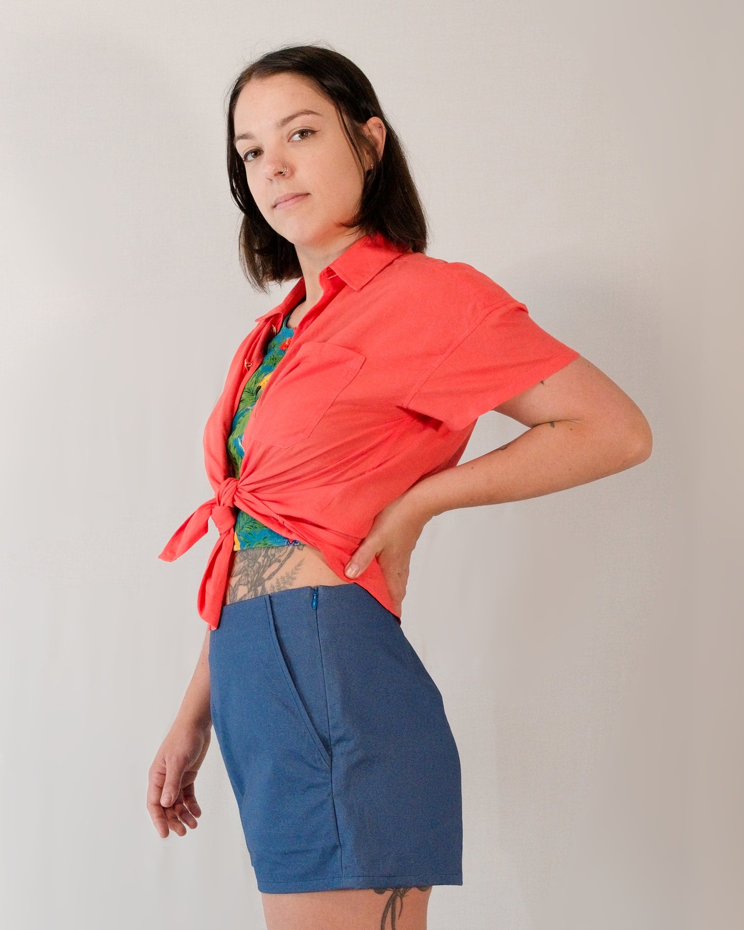 Short-sleeved blouse in callistemon red tied into a shirt knot. Paired with Kingfisher A-line shorts in blue.