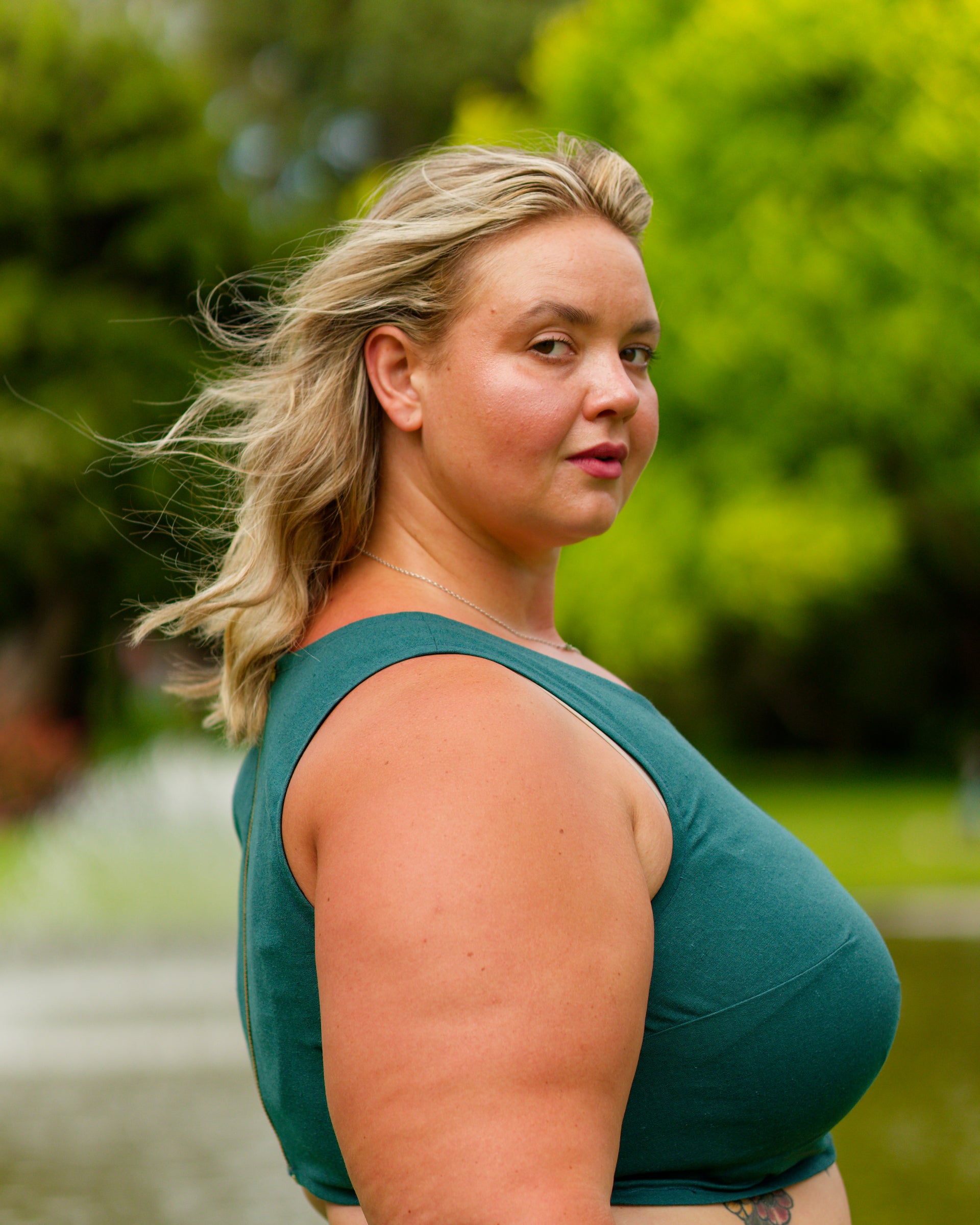 Right side of a sleeveless crop top in deep emerald with bust dart for shaping.