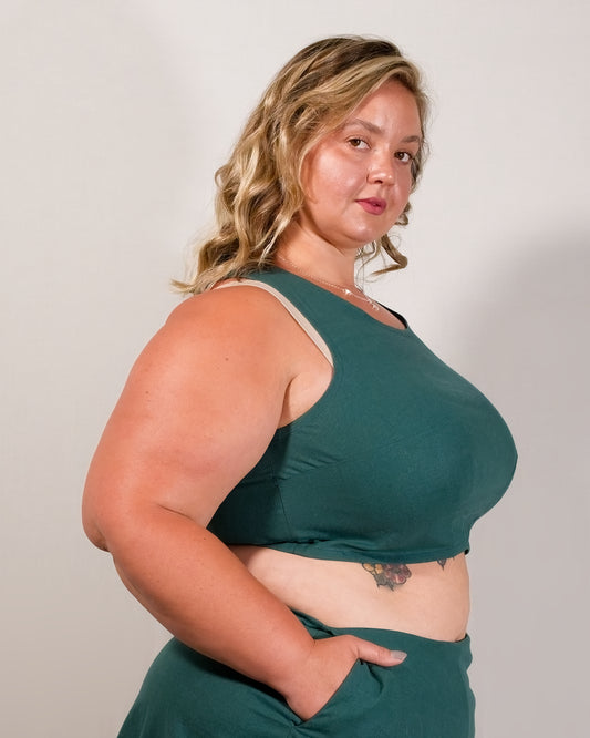 Right side of a sleeveless crop top in deep emerald with bust dart for shaping.