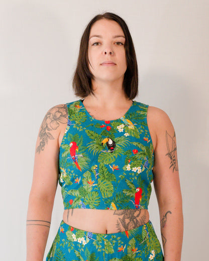 Front of a sleeveless crop top in a turquoise parrot print. The two waist darts form a V-shape below the bust.