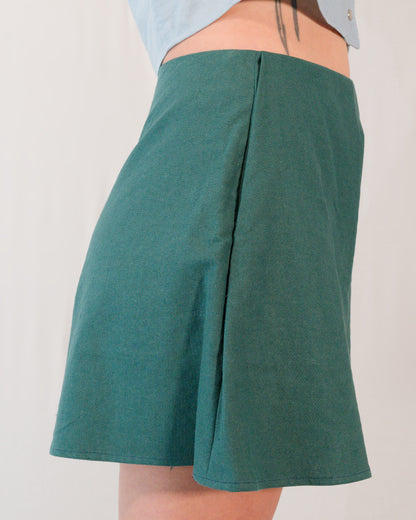 Right side of flared shorts in deep emerald. Side pocket is mostly hidden.