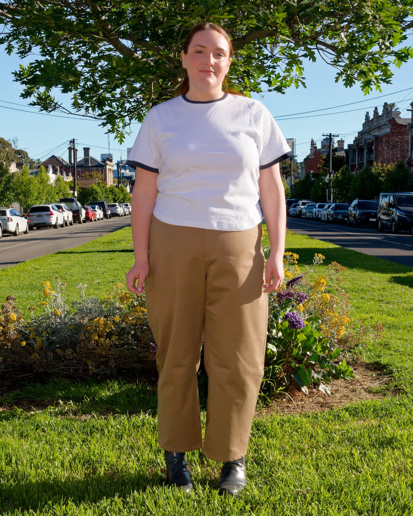 Lydia modelling a white t-shirt and khaki barrel-leg jeans on a nature strip.