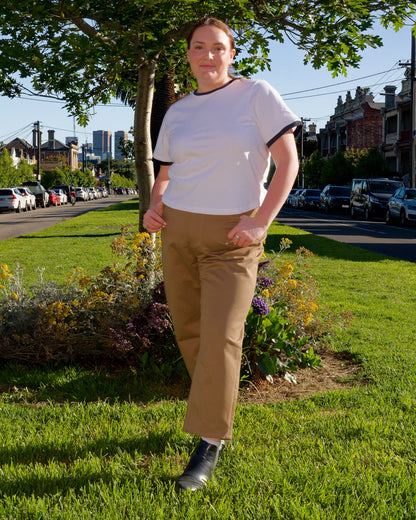 Lydia modelling a white t-shirt and khaki barrel-leg jeans on a nature strip.