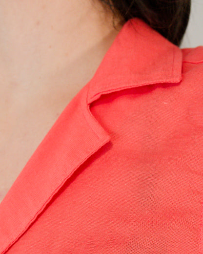 Close-up of camp collar on sleeveless blouse in callistemon red.