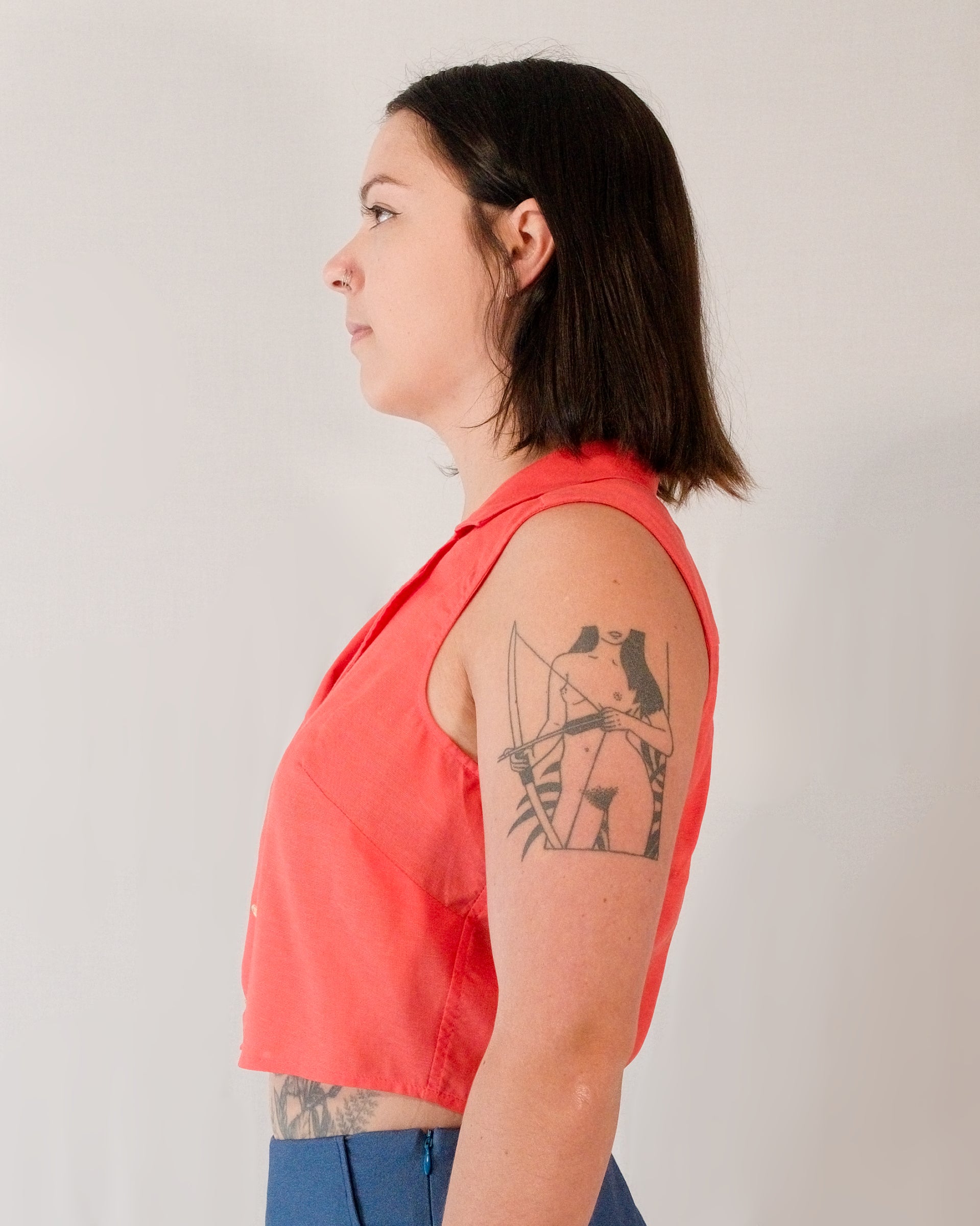 Left side of sleeveless blouse in callistemon red.