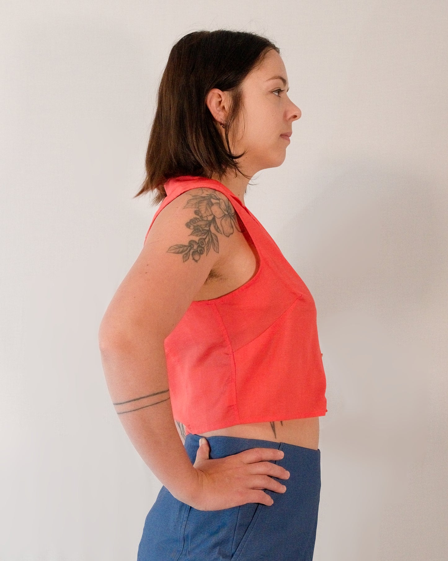 Right side of sleeveless blouse in callistemon red.