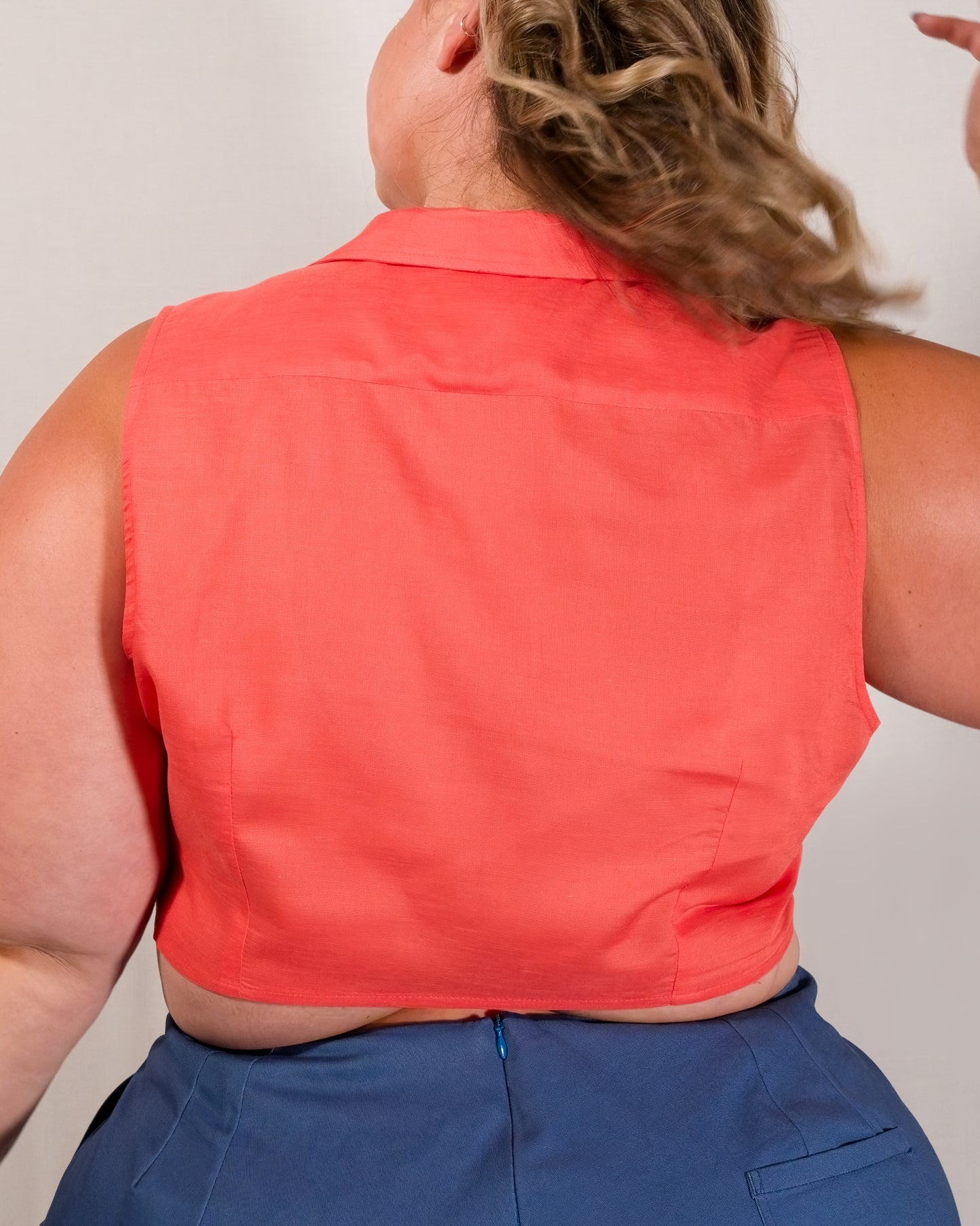 Back of sleeveless blouse in callistemon red with back darts for shaping.