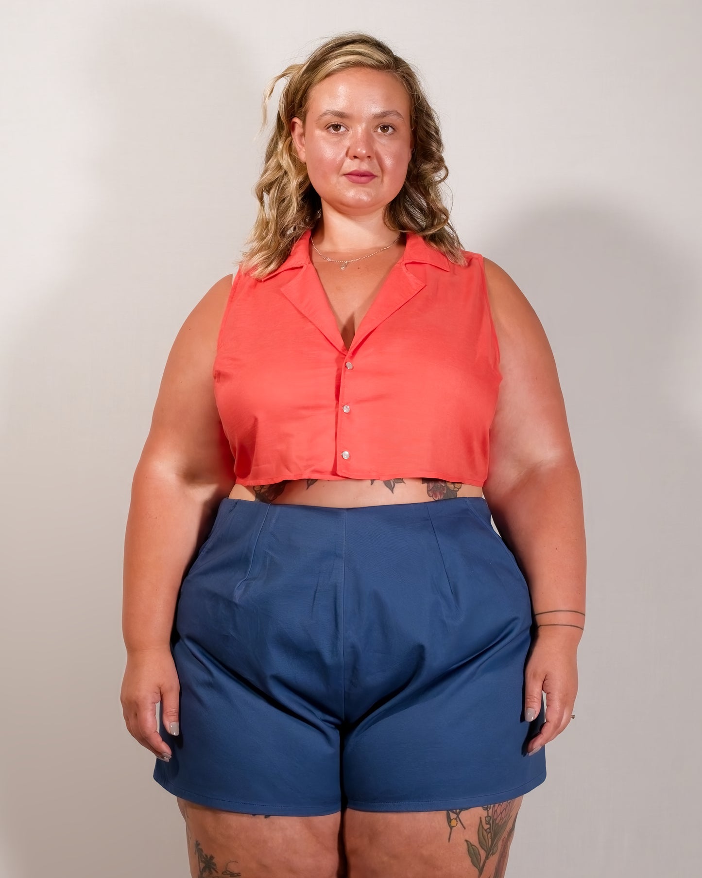 Sleeveless blouse in callistemon red with camp collar and pearl snaps.