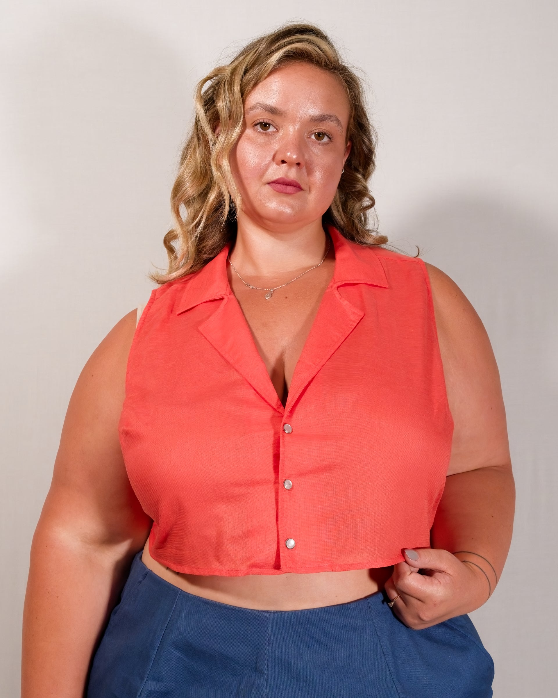 Sleeveless blouse in callistemon red with camp collar and pearl snaps.