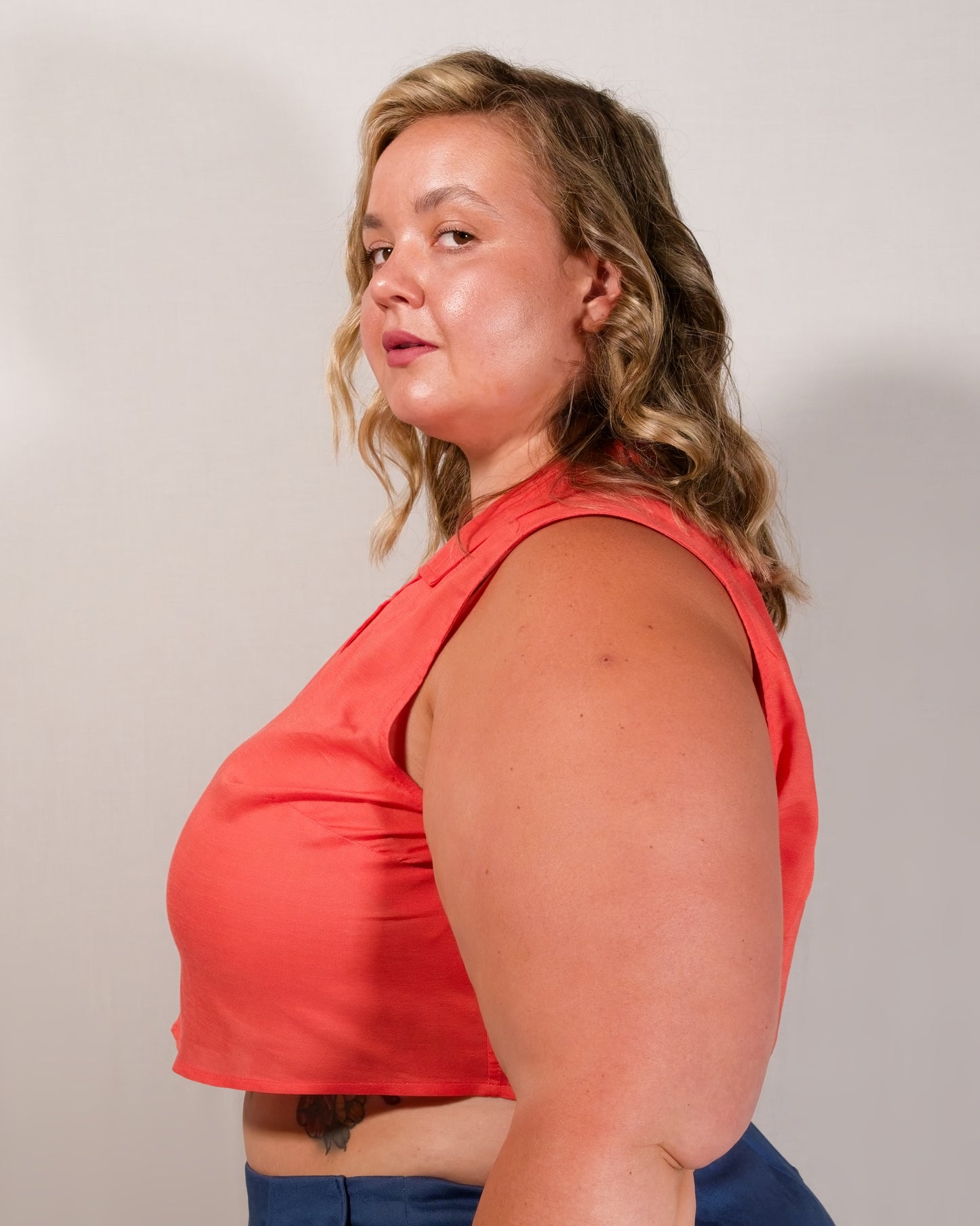 Left side of sleeveless blouse in callistemon red with bust dart for shaping.