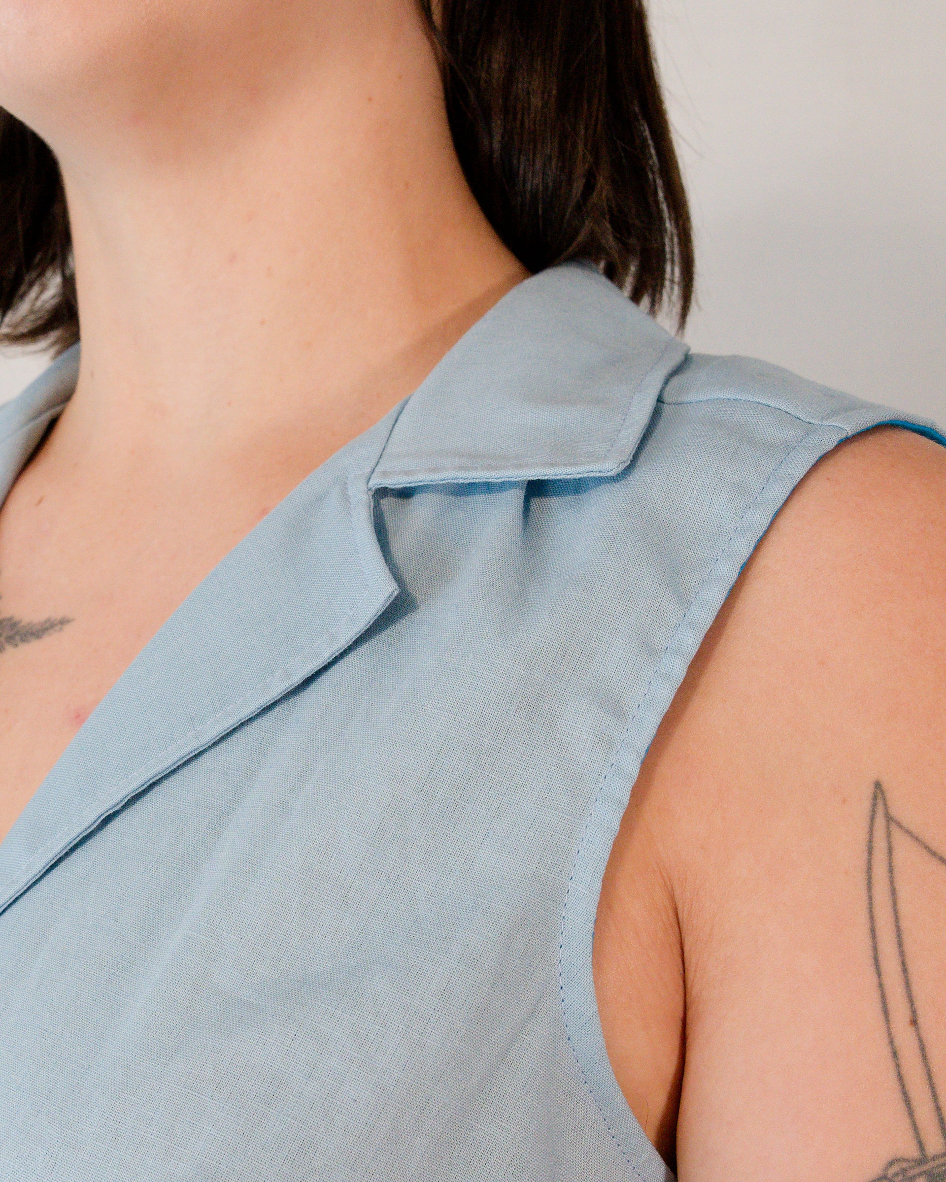 Close-up of camp collar on sleeveless blouse in skyline blue.