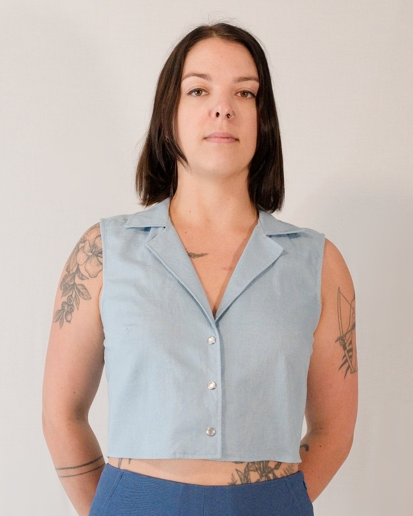 Front of sleeveless blouse in skyline blue with camp collar and pearl snaps.