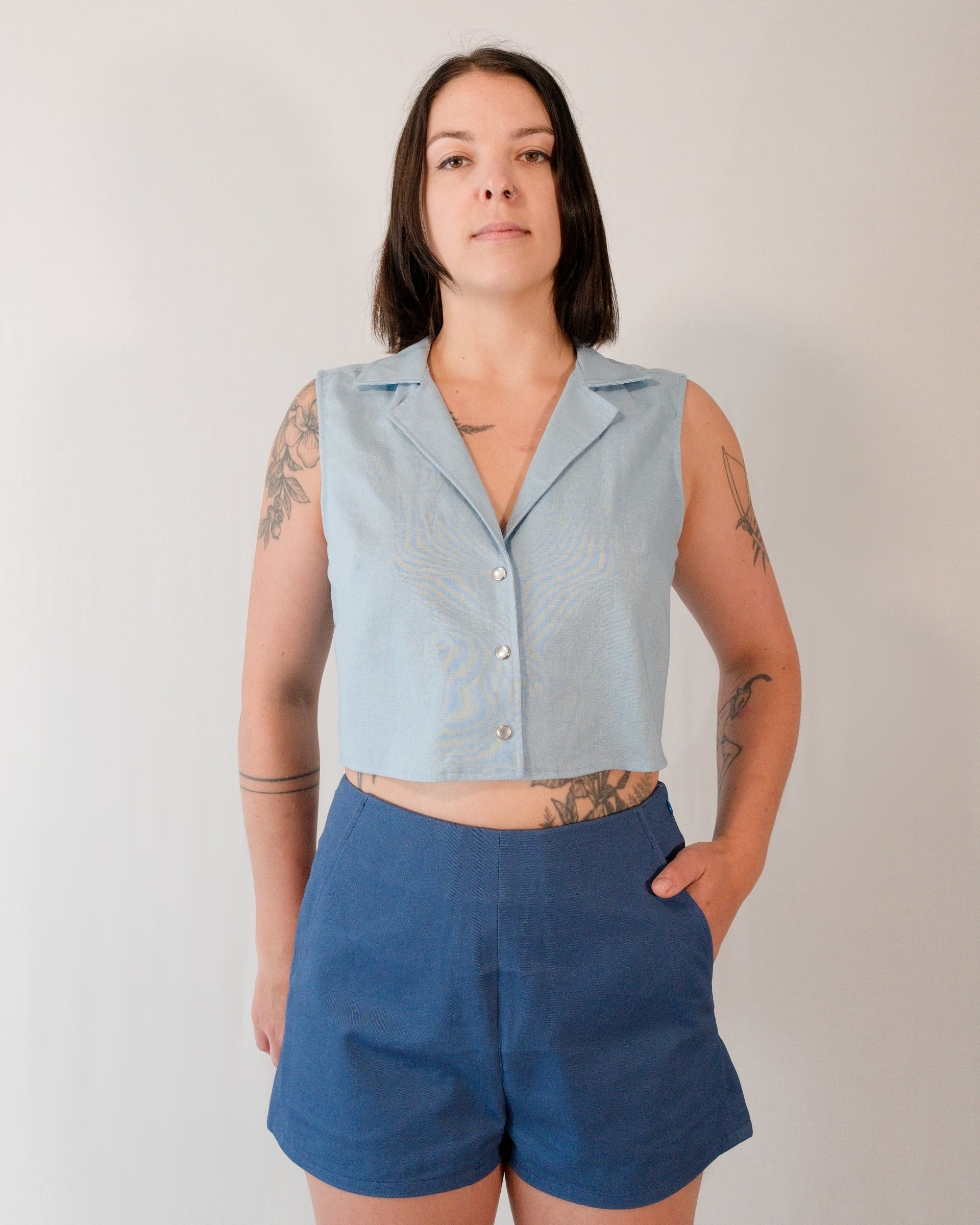Front of sleeveless blouse in skyline blue with pearl snaps. Paired with Kingfisher A-line shorts in blue.