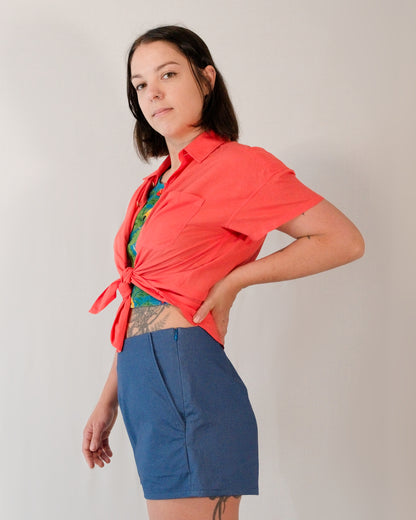 Short-sleeved blouse in callistemon red tied into a shirt knot. Paired with Kingfisher A-line shorts in blue.