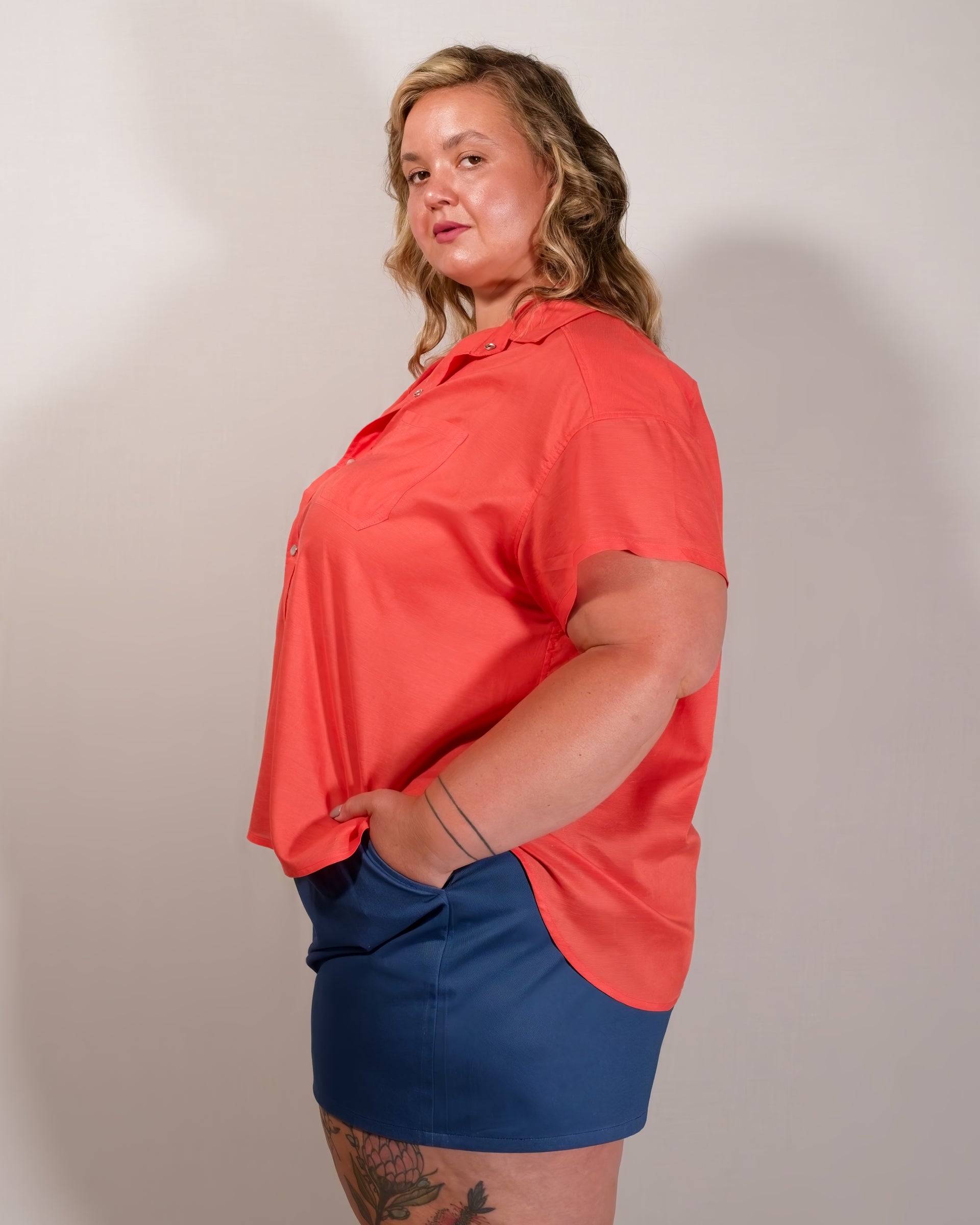 Left side of a short-sleeved button-down blouse in callistemon red.